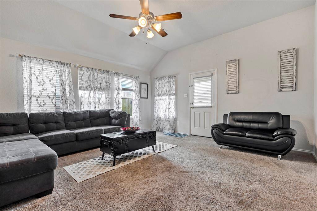 Bright and inviting, this spacious carpeted living room offers plenty of room for relaxation and entertaining.