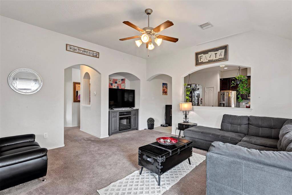 Another angle of the spacious living room, offering a peek into the kitchen just beyond.