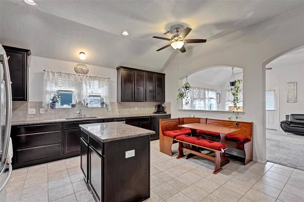 This spacious kitchen boasts beautiful tiled floors and elegant granite countertops, perfect for both cooking and entertaining