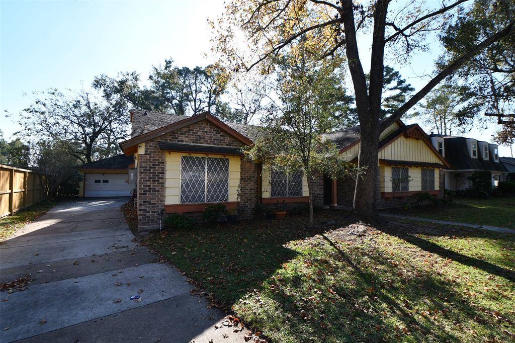 Beautiful home with a cozy cottage feel, features diamond-patterned windows and a spacious driveway. Surrounded by mature trees, offering shade and privacy. Perfect for those seeking a serene residential setting.