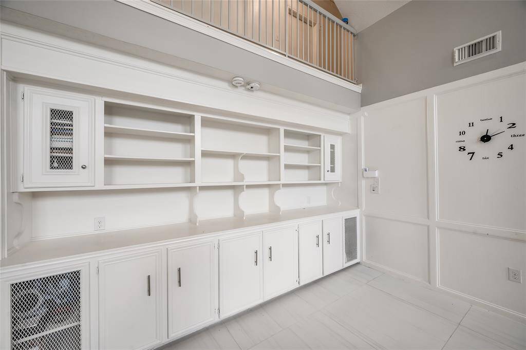 Discover the charm and functionality of this versatile nook, featuring custom cabinetry designed for optimal storage and organization. Ideal for a cozy reading corner or a stylish home library, this space offers ample shelving for books, decorative items, or personal collections. Provides a perfect spot for showcasing your favorite items.