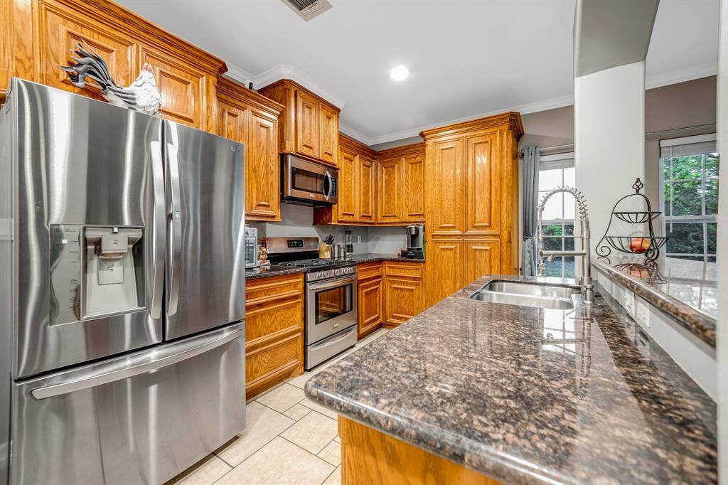 This kitchen boasts of Stainless Steele appliances,, built-in microwave, pullout drawers, granite counters, high-end fixtures and canister lights