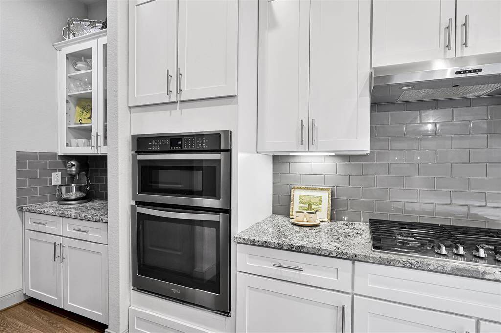 Tucked away you'll find a butlers pantry with glass front top cabinets and additional lower cabinets for extra storage.