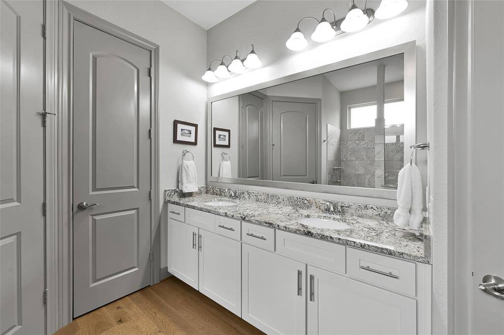 The spa-like primary bath features sleek granite counters with double vanities and a full mirror.