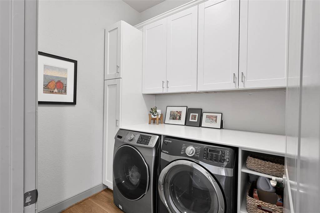 The large laundry room features a countertop for folding and built in cabinets and shelving for additional storage.