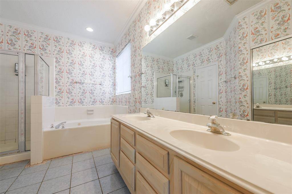 Indulge in the elegant primary bath with double vanities, a soaking tub, and a separate walk-in shower for a spa-like experience.