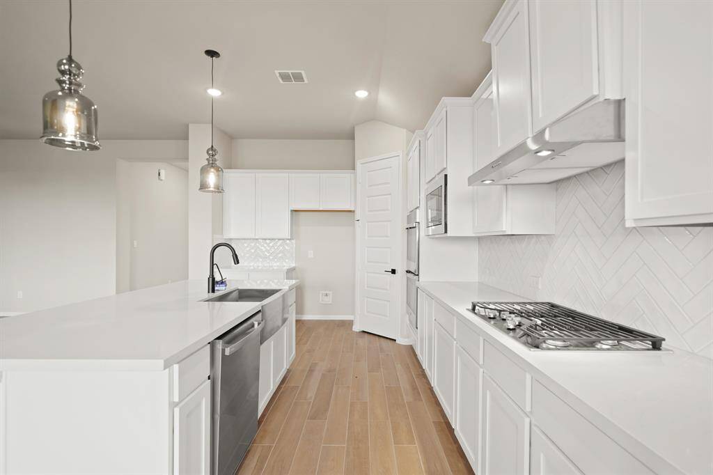 Lovely kitchen with white cabinets and quartz countertops