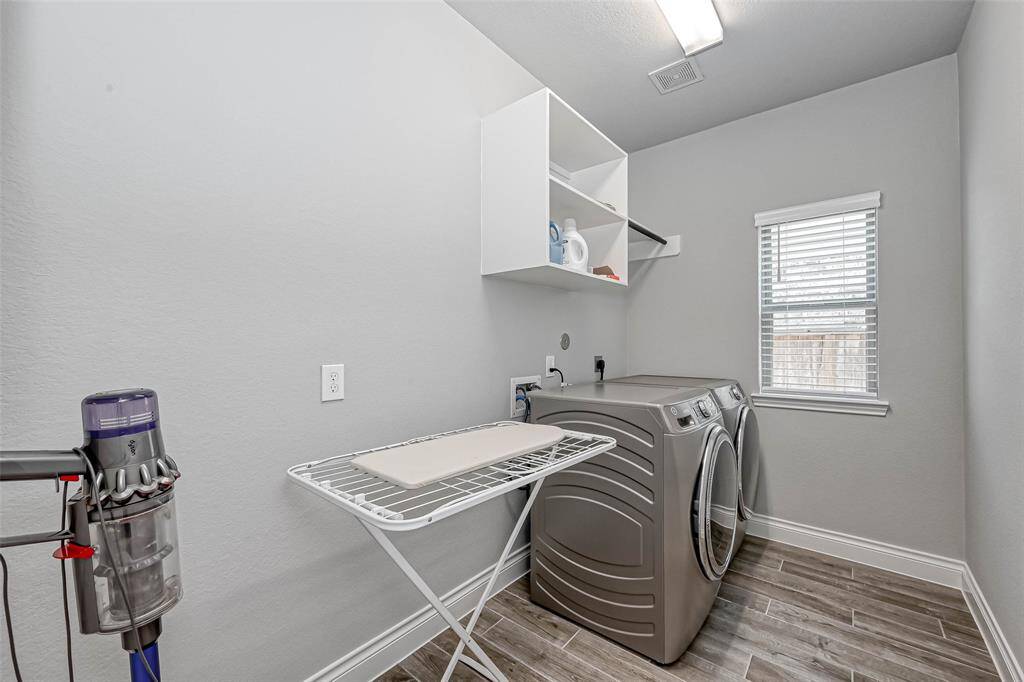 The fabulous utility room featuresneutral paint and plenty of space for an extra refrigerator if wanted. You also have shelving for storage of all of yourcleaning supplies and detergents.There is also a hanging rack foradded convenience.