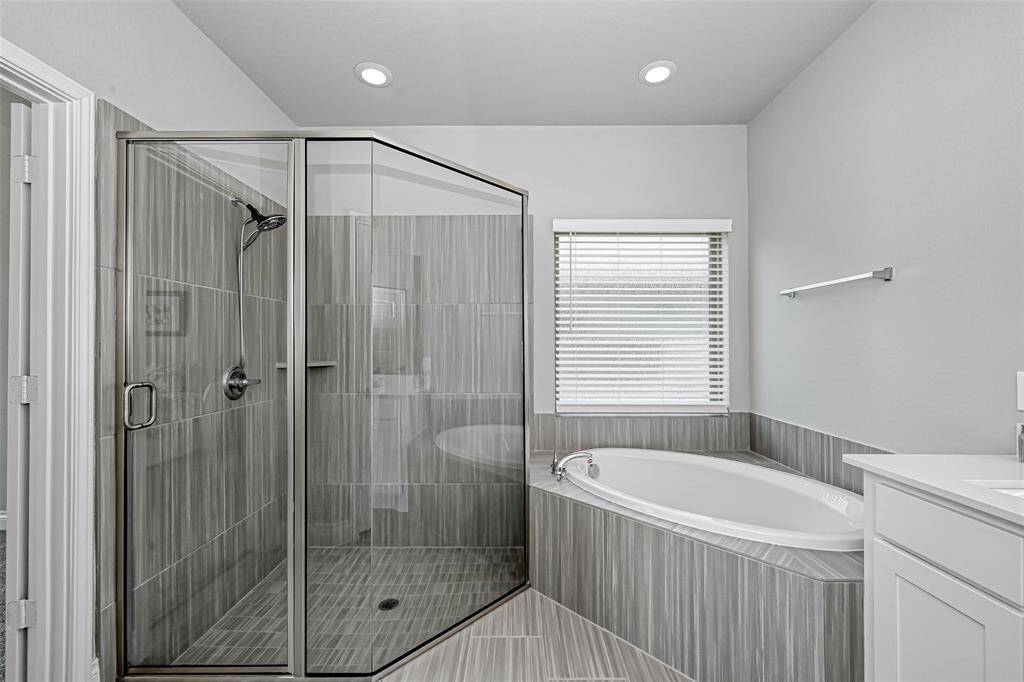 A soaking tub sits beneath anobscure window that allows naturallight without compromising privacy.You also have an oversized walk-in showerwith a custom glass enclosure, andnickel finishes.