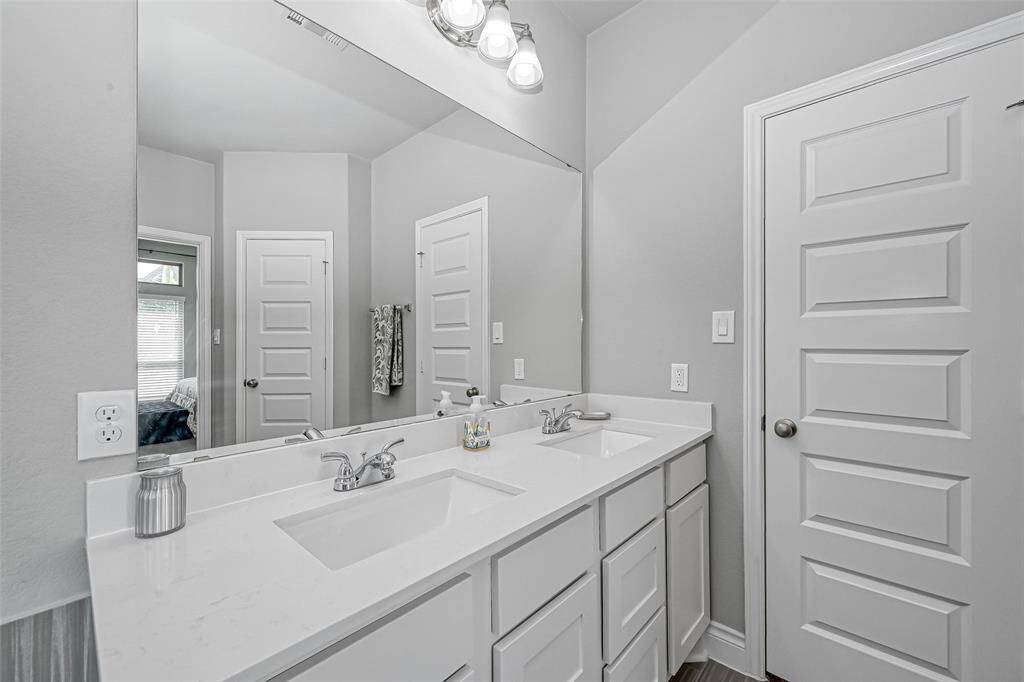 A closer look at the vanityshows gorgeous cabinetry with shaker style cabinets, acomplementing countertop, dual sinks, andnickel finishes.