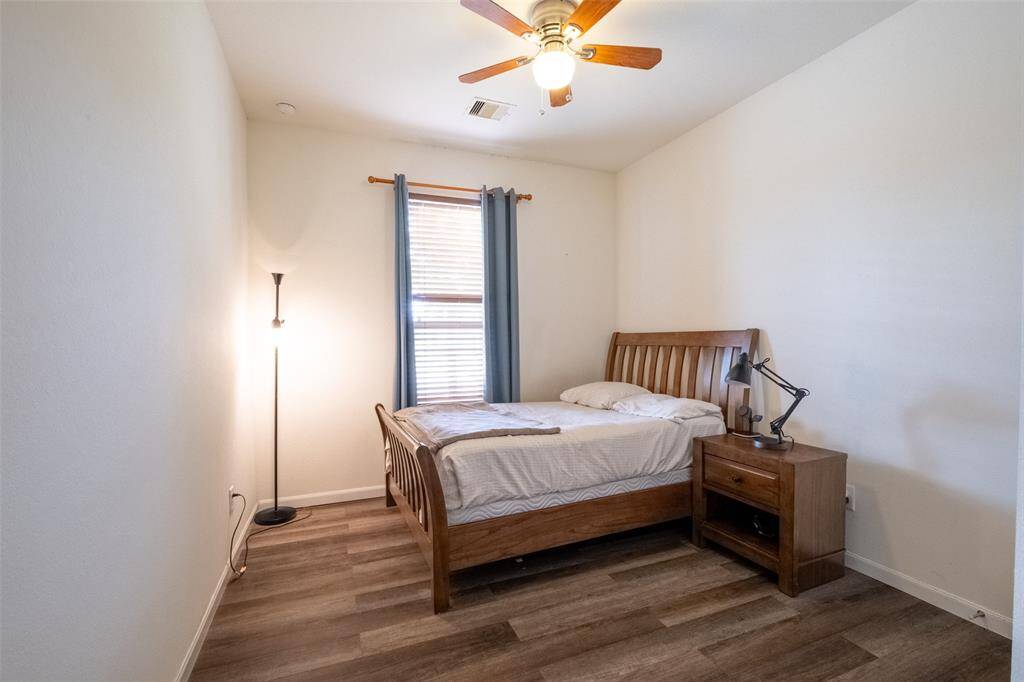 Cozy bedroom with warm natural light, and a modern ceiling fan for comfort.