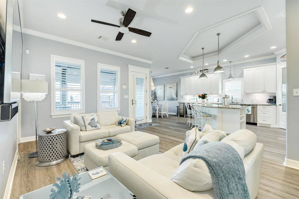 View of the living room, kitchen and dining area. The door in view is the main entrance.