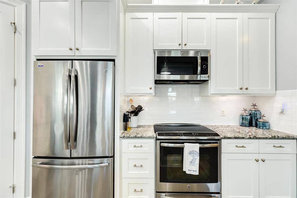 Kitchen features GE Monogram series appliances in stainless steel.