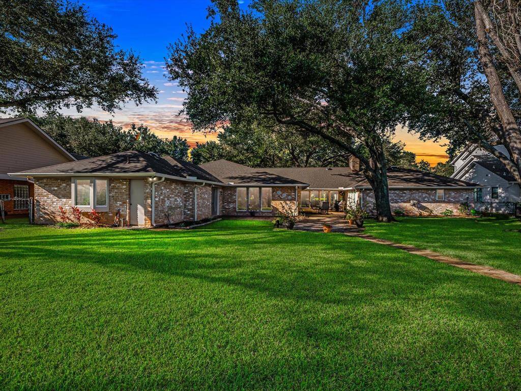 Expansive backyard shrouded by mature Oak and Pecan trees