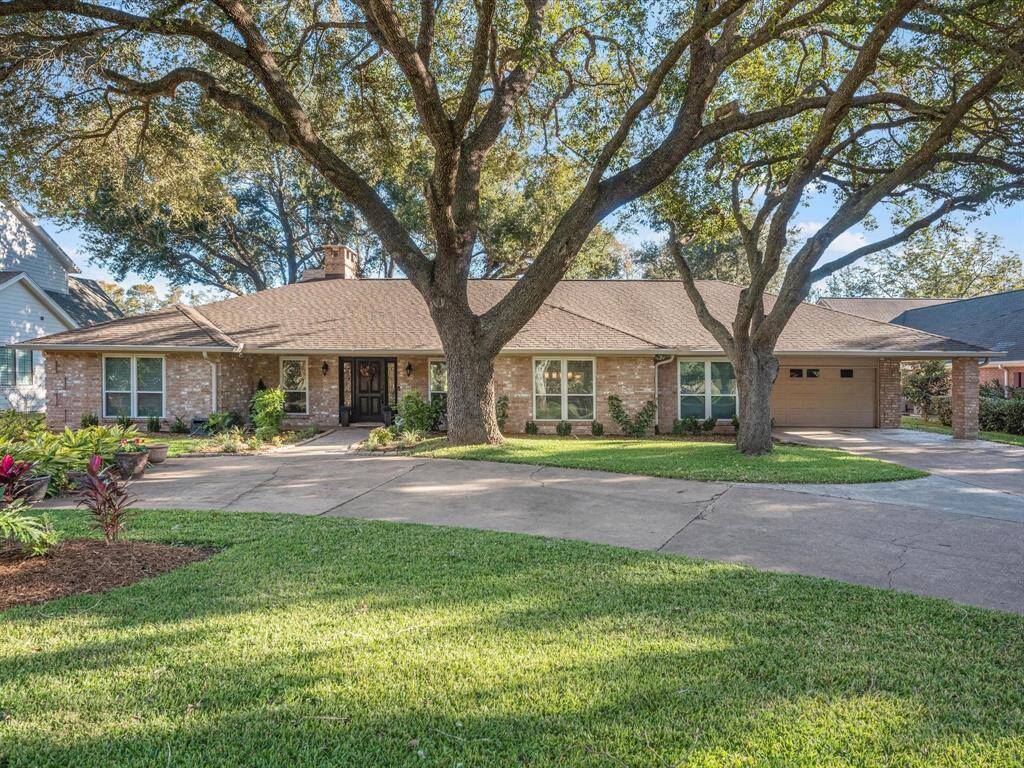 Beautiful landscaped yard adorned with the most gorgeous trees (no pine trees here)