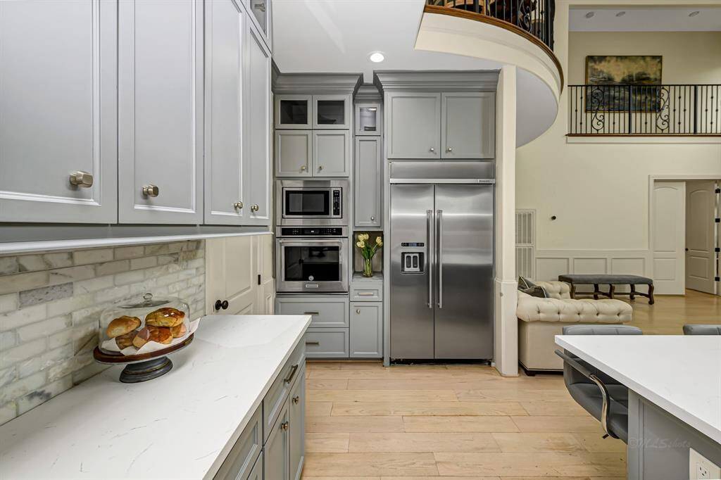 Gorgeous quartz countertops are nicely accented by the tumbled stone backsplash