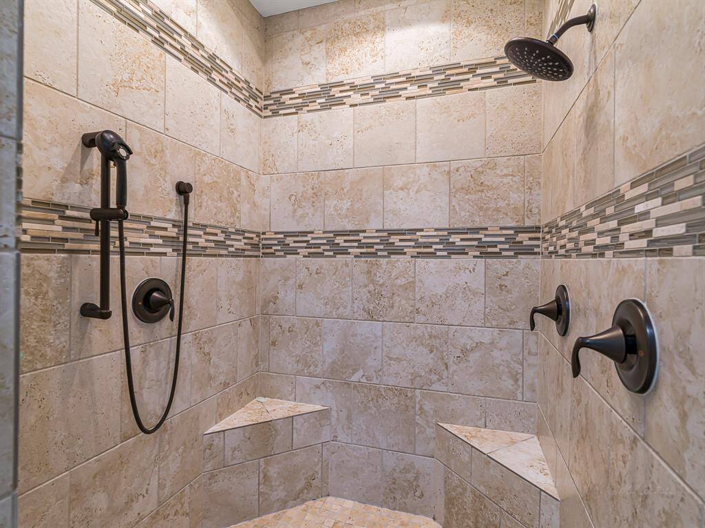 The primary shower boasts clean lines and luxurious finishes.
