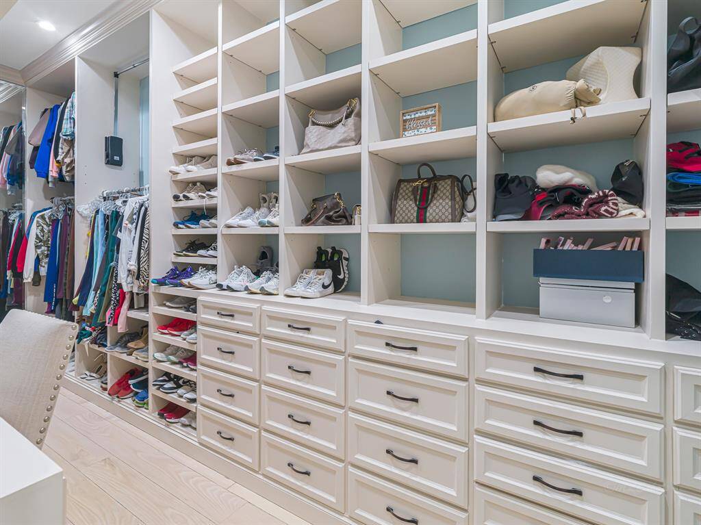 A walk-in closet offers ample storage and a well-organized layout.  This is just one of 2 closets in the primary suite