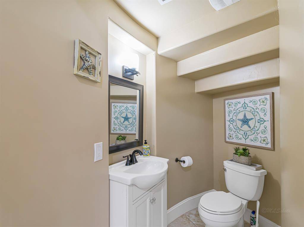 The powder room is s thoughtfully designed with modern fixtures and clean lines just under the stairs.