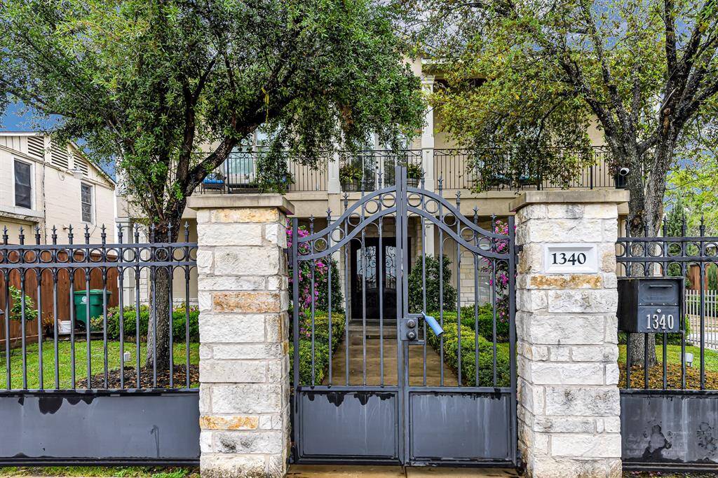 This luxurious home with a wrought iron gate exudes elegance, sophistication, and timeless appeal
