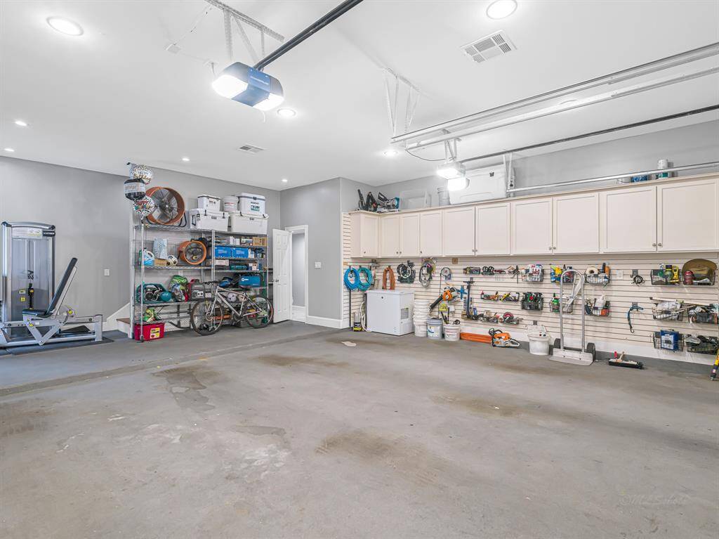 The garage features ample storage space with organized shelving and cabinets, ideal for tools, equipment, and recreational gear.