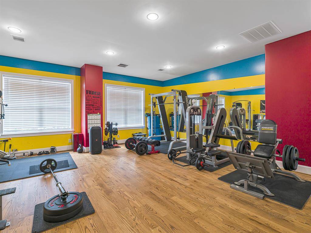 The private gym above the garage features a vibrant design and a abundant space for all your workout equipment (equipment pictured is not included in sale) offering a dedicated space for fitness and wellness.