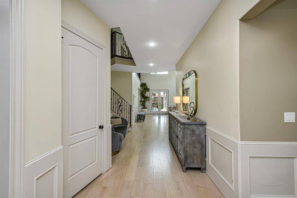 Immediately as you enter through the large custom doors you are greeted by the long corridor which aligns perfectly with glass doors at the rear of the home, allowing an unobstructed line of sight to the lush backyard
