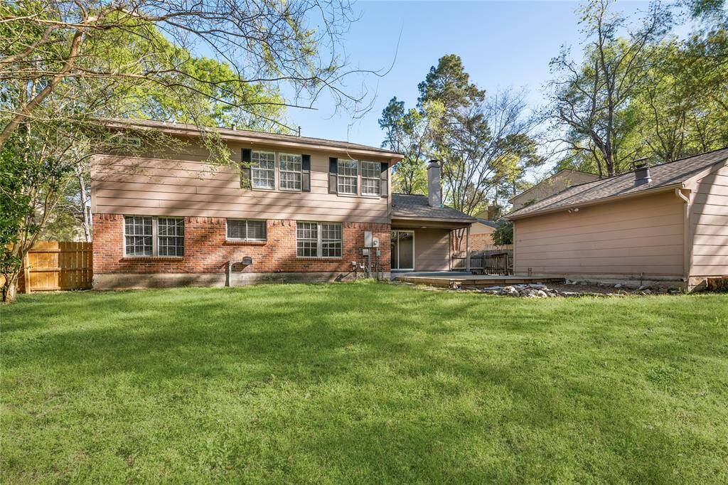 Well-maintained lawn,and a detached garage on the right and mature trees surrounding the property, offering privacy and shade.