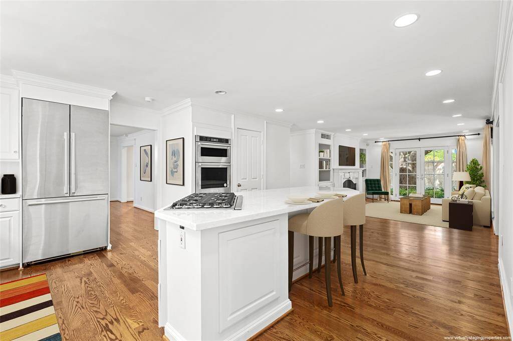 New 48” high end Dacor stainless steel french-door refrigerator and drawer freezer (2023 per seller). Upper and lower cabinetry offers plenty of storage. Divided lite window over sink brings in natural light. Custom designer valance.  Glass front cabinets flanking the kitchen window.