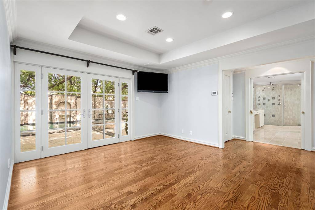 First floor primary bedroom doors open to patio, pool, spa and resort style living atmosphere.
