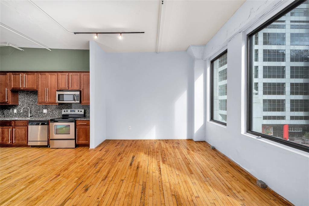 The facing alcove to right of Kitchen is a great focal point area to place your bed, create a TV entertaining area or place desk & bookcase to create a study area.  Kitchen has beautiful wood stained cabinetry to add a sense of warmth to the home.