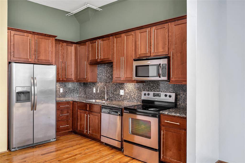 Kitchen boasts shaker style cabinets and drawer fronts with designer pulls, stainless steel appliances, slab granite countertops and backsplash and undercabinet lighting.  Abundant storage in the cabinets and the open area in front is great for dining table or mobile island!