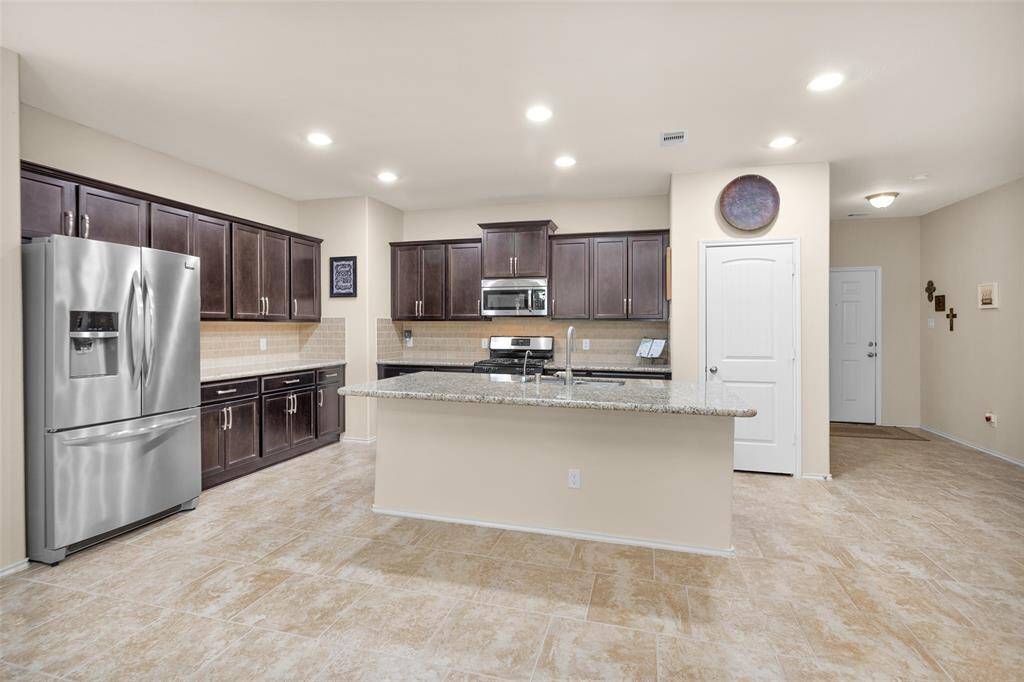 Kitchen island with sink and breakfast bar.
