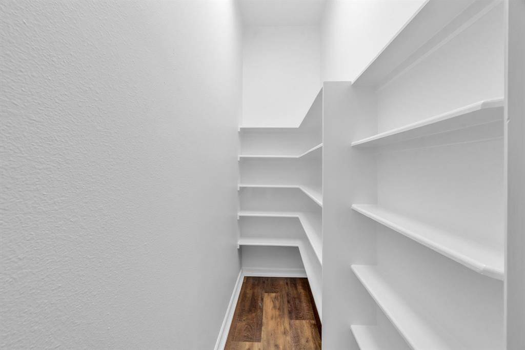 The freshly painted walk-in pantry is both spacious and practical, offering the perfect solution to organize and store all your kitchen essentials with ease and style.