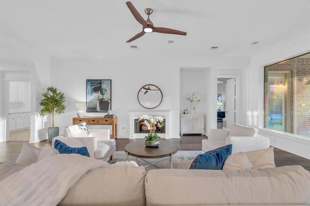 View into the living room from the kitchen. To the left is the oversized laundry room and to the right is luxurious primary bedroom.