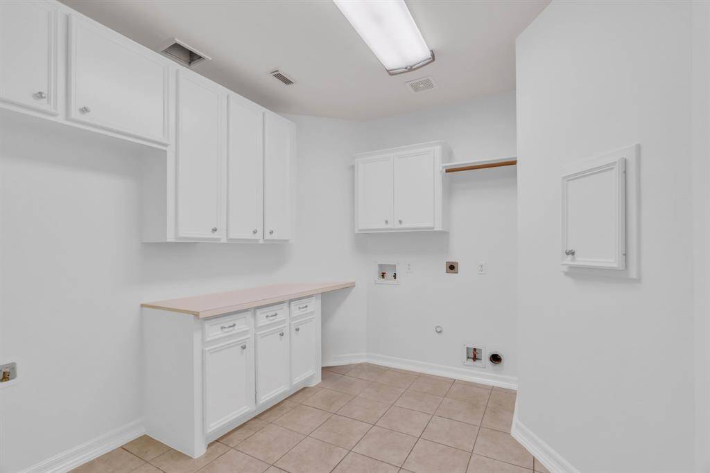 The massive laundry room is truly a dream, offering ample space to add an extra refrigerator and featuring an abundance of cabinets and countertops. With plenty of room to work, this well-appointed space will make even the most mundane laundry tasks feel effortless and enjoyable.