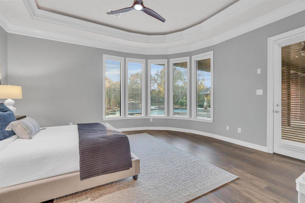 The primary suite offers serene views of the outdoor paradise and features a private door leading directly to the outdoor patio, making it a convenient retreat for relaxation and easy access to the stunning outdoor spaces.