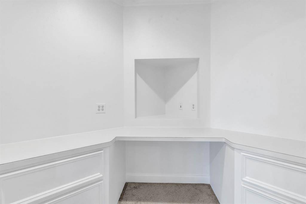 The desk enclave off of the game room offers a quiet, dedicated space for work or study, providing the perfect balance of functionality and style while remaining conveniently close to the entertainment hub of the home.