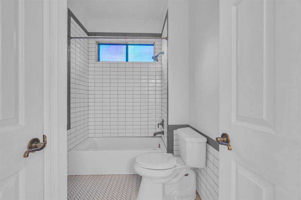 This recently renovated bathroom boasts a fresh, modern look with new ceramic wall tile, a brand-new bathtub, and sleek new faucets for the sinks, tub, and shower. The updated vanities and sinks add both functionality and style, while the new light fixtures and mirrors complete the refreshed, elegant ambiance.