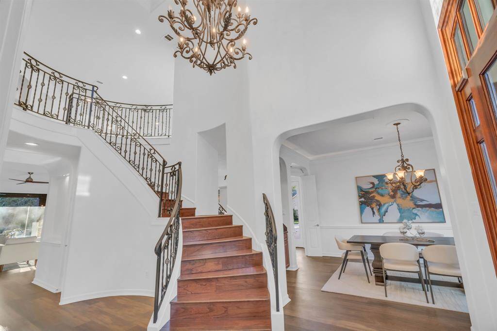 Step into the grand foyer and be captivated by the sweeping spiral wood staircase, a dazzling chandelier, and freshly painted walls that combine to create an elegant statement of openness and brightness. This stunning entryway sets the tone for the beauty that lies ahead.