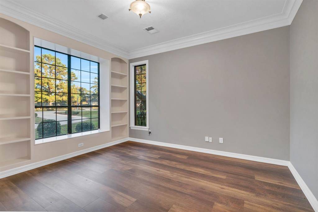 To the left of the grand foyer, you'll find a spacious private study, complete with built-in bookshelves. This elegant space offers the perfect retreat for work, reading, or quiet reflection.