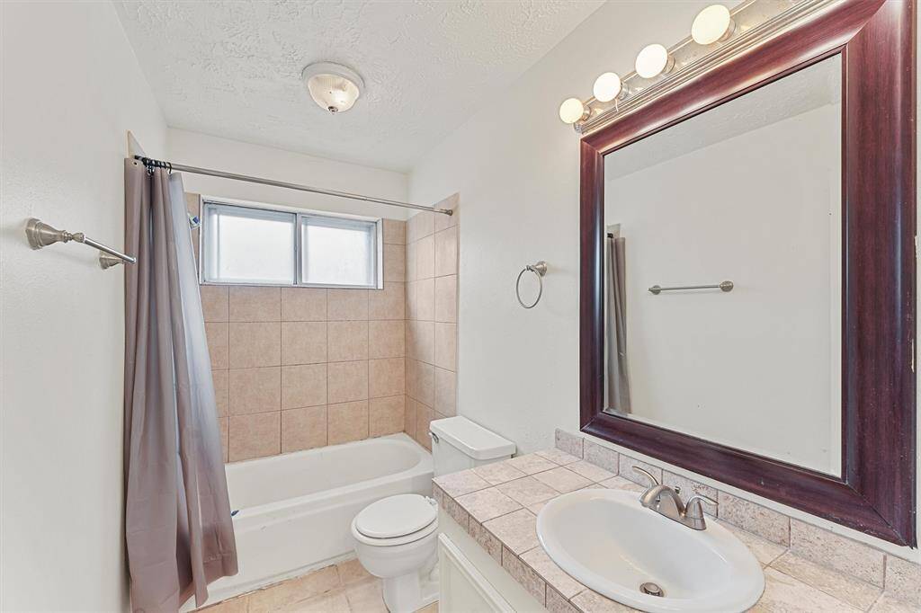 Secondary bathroom with tiled bathtub/shower combo.
