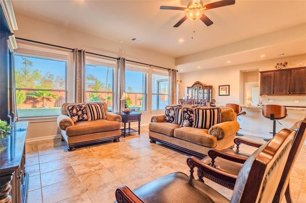 The living room features large windows that fill the space with natural light and offer picturesque views of the backyard.