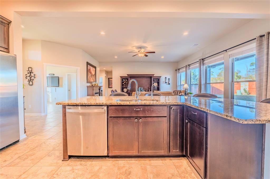 Stainless steel appliances, dark wood cabinetry, and granite countertops define this stylish and functional kitchen
