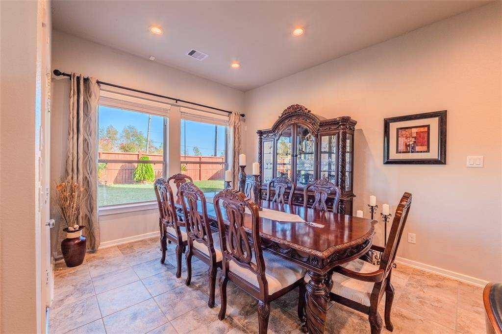 This dining room boasts elegant finishes and large windows that invite natural light while offering serene views of the backyard.