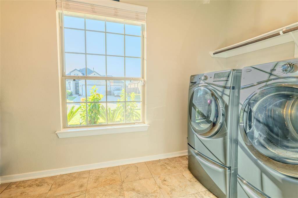 A well-lit laundry room offers ample natural light through a large window, providing a bright and inviting space for household tasks.
