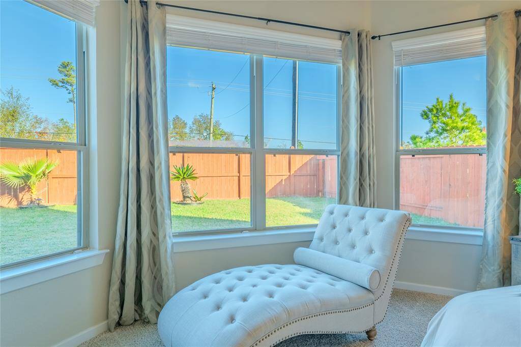 The spacious primary bedroom boasts large bay windows that provide serene views of the backyard.