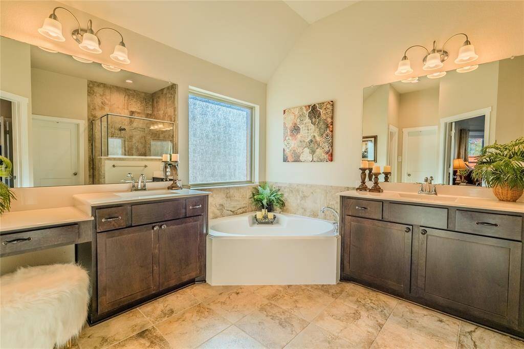 The primary bathroom boasts separate double sinks, offering convenience and personal space, beautifully complemented by sleek countertops and stylish fixtures.