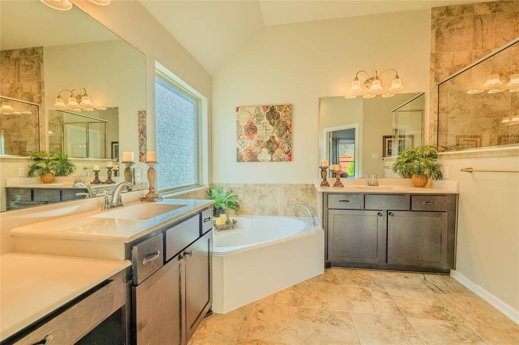 The primary bathroom features a sleek vanity with ample counter space, complemented by soft lighting and a modern design.