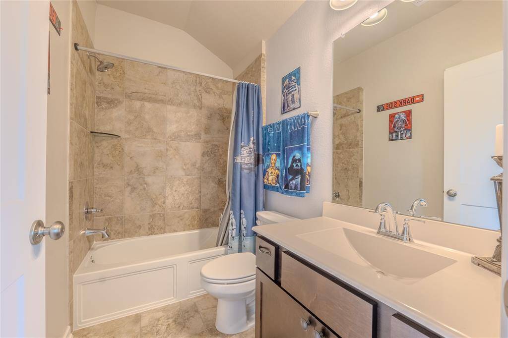 The bathroom showcases updated fixtures, tile flooring, and a tub/shower combination, creating a comfortable space for family or visitors.